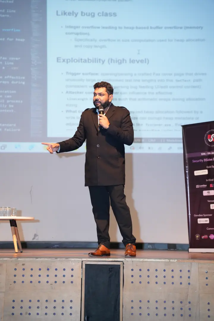 A speaker pointing at notes projected on the wall behind
